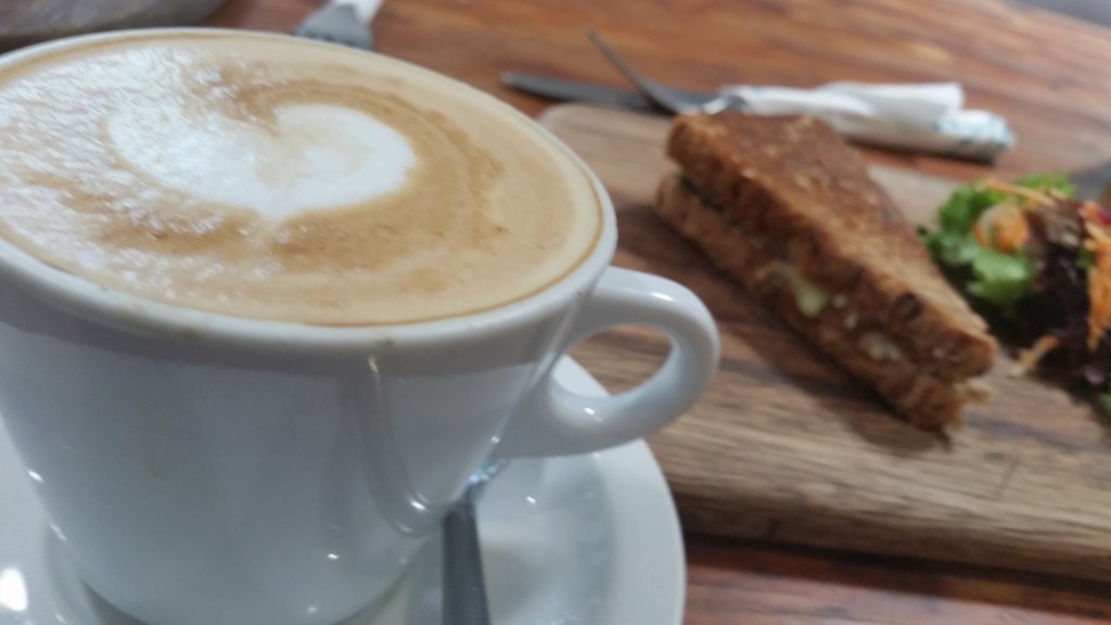 Cheese, tomato and pesto toasted sandwich and a cappuccino make for a delicious light snack.